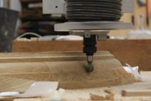 Curved molding being refined on CNC