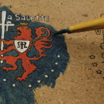 a small, painted lion crest