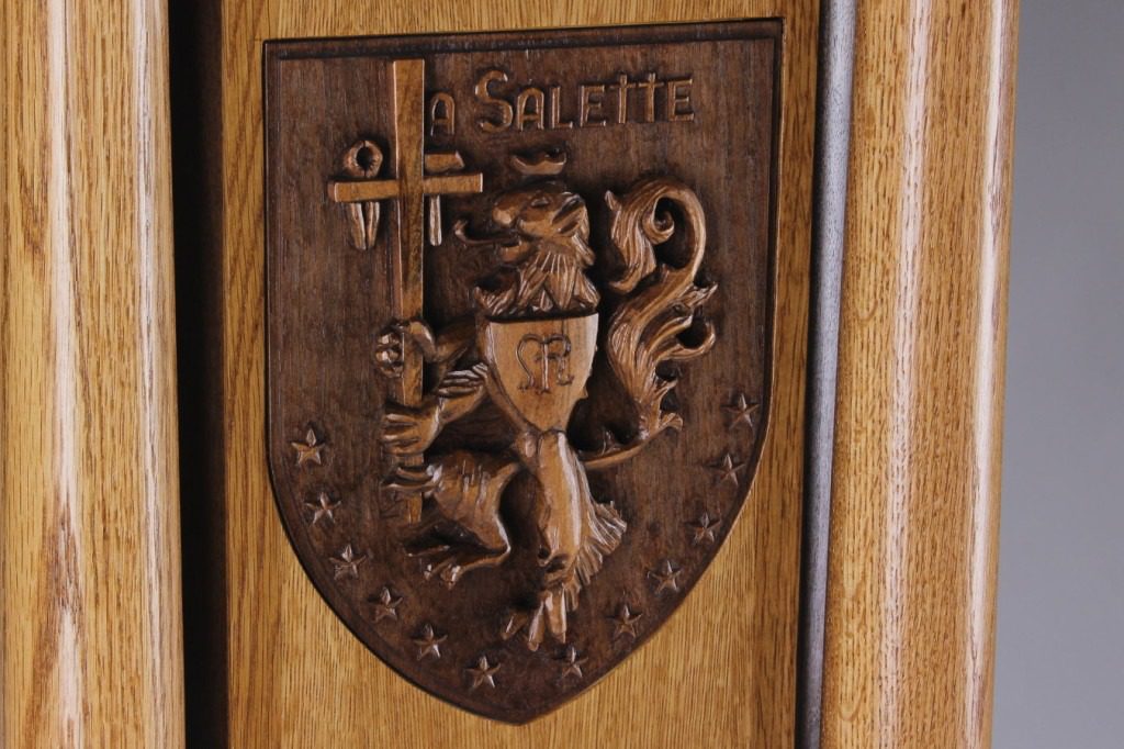 Image of the La Salette crest in hand-carved walnut and cherry
